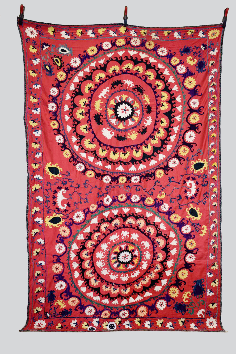 Uzbek red cotton suzani, Uzbekistan, 20th century, embroidered in basma stitch in bright silks,