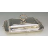 A silver entrée dish of conventional rectangular form with stylised shell and scroll handle,