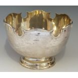 A large silver bowl, the plain body with raised shaped upper rim, stepped pedestal foot,