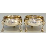 A near pair of George III silver cauldron shaped salts with plain bodies,