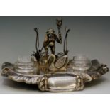 A silver plated inkwell in the form of a pond with youth standing at the edge,