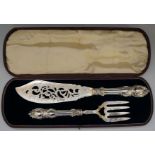 A pair of silver fish servers, the handles with scrolling foliate design,