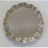 A silver salver, the plain body surrounded by stepped scalloped edge, three stylized paw feet,