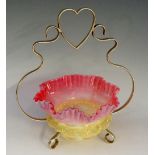 A vaseline and cranberry opalescent sweetmeat dish with ruffled rim and applied band of stylised