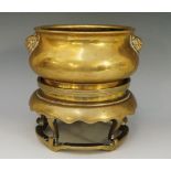 A Chinese bronze censer of compressed sack shape with pair of mask handles, circular foot,