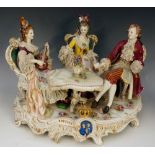 A Dresden porcelain figure group modelled with a young gentleman and two ladies,