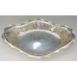 An Edwardian silver dish with pierced scrolling foliate sides and scalloped ruffled rim,