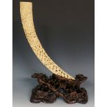 A Cantonese tusk finely relief carved with figures within temple landscapes,