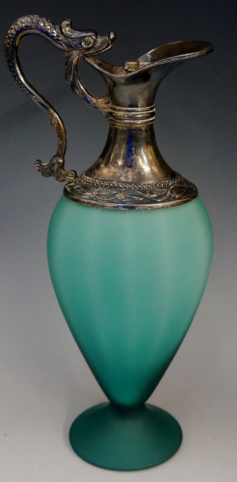 A moulded sea green frosted glass claret jug with white metal mounts,