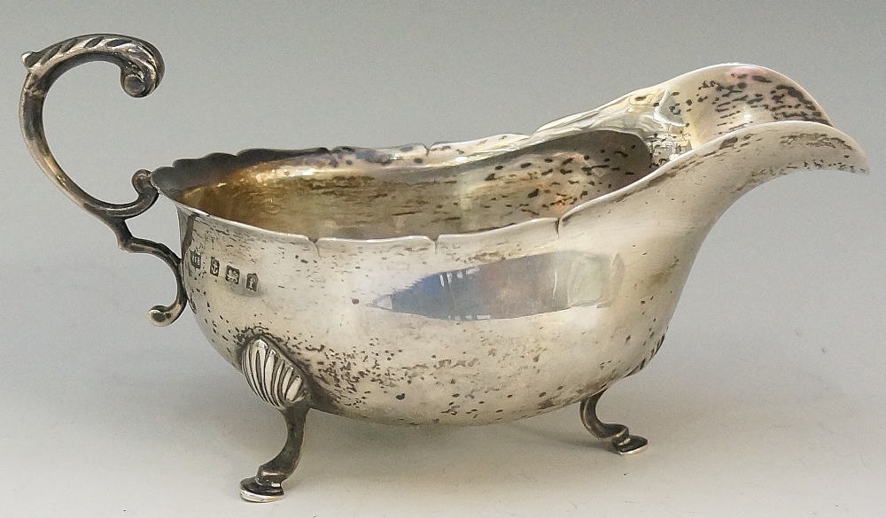 A silver sauce boat of conventional form, flying acanthus cast handle,