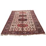 A good Caucasian carpet with four central medallions in a row, the two innermost red,