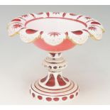 A Victorian white cased cranberry glass tazza, the scalloped rim star and circle cut,