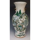 A Chinese white crackle glaze vase decorated with mountains and buildings in extensive tree filled