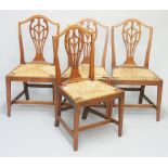A set of four Heppelwhite style elm dining chairs with pierced vasular shaped splats carved floral