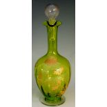 A green glass liqueur decanter the body gilded with poppies, trefoil form ruffled rim,