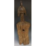 An African trunk carved tribal figure, the head with stylised headdress and ears on a tall neck,