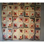An early to mid 20th Century log cabin patchwork quilt made up of seven by ten multi coloured