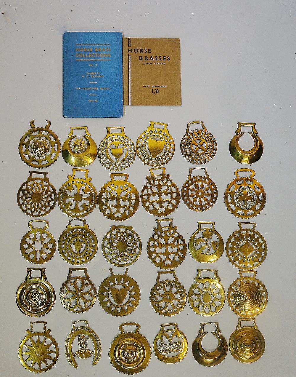 A quantity of horse brasses together with two books,