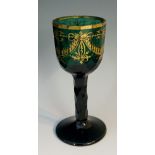 A green wine glass, the bowl and stem slice and facet cut,