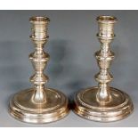 A pair of silver candlesticks, each with reeded knopped stems and stepped circular feet,