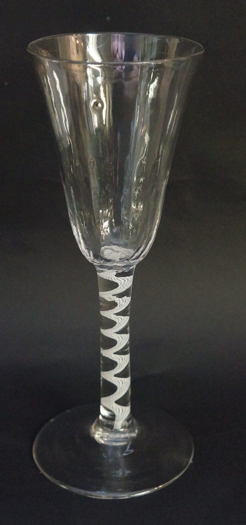 A tall Georgian ale glass with rounded trumpet form bowl, the lower half lightly fluted,