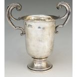 A silver trophy cup with two S scroll handles, plain body, circular pedestal foot,