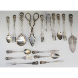 A silver plated cake set comprising six dessert forks, four teaspoons, a pair of sugar nips,