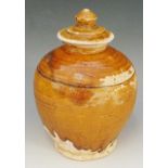 A Chinese Tang dynasty amber glazed pale terracotta baluster storage jar, 15cm high,