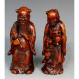 A pair of Chinese bamboo carvings of elderly sages, one holding a fan,