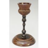 Treen - a turned wooden candlestick with thistle shaped nozzle,