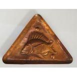A Newlyn School copper triangular dish, embossed with a stylised fish on a textured ground, 15.