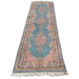 A good Kirman runner, three floral diamond shaped medallions on light blue ground,