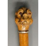 A 19th Century walking stick, the terminal carved with a dog's head, amber glass eyes,