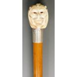 A 19th Century walking stick, the ivory terminal carved as Mephistopheles, faceted glass chip eyes,