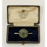 A 19th Century gilt white metal brooch centred on a cushion cut green stone within seed pearl and