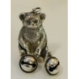 A novelty child's silver rattle in the form of a teddy bear with bells attached to its paws,