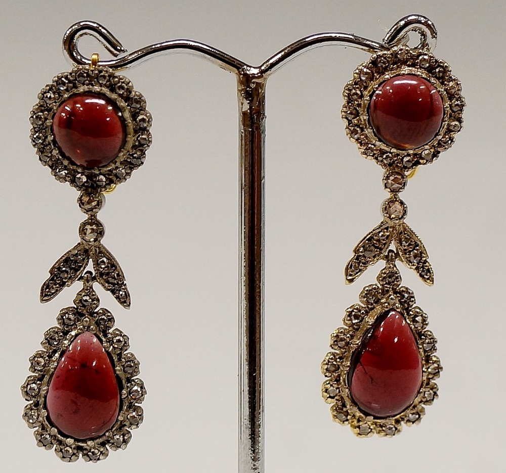 A pair of 18ct gold garnet and diamond chip pendant earrings the tear shaped drops with diamond