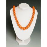 A pink coral bead necklace of graduated beaded form the clasp with turquoise set pink coral bead,