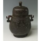 A Chinese bronze jar and cover of two handled bellied form cast with a band of stylised leaves on a