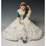 A Royal Dux figure of a seated young woman with floral decorated crinolin dress, 28cm high,