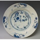 A 19th Century Dutch Delft circular dish painted to the centre with flowerheads and leafage within