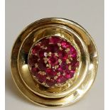 A yellow gold and ruby dress ring the circular domed centre set nineteen rubies on a double concave