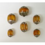 Six various silver coloured metal mounted amber beads,