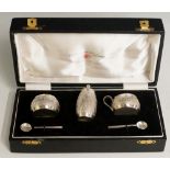 An Indian cruet set comprising salt cellar, pepper pot, mustard pot and two condiment spoons,