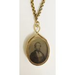 A late 19th Century oval locket with photographic portrait, half length, of a gentleman,