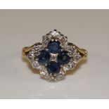 A sapphire and diamond cluster ring claw set with four circular sapphires around illusion set