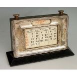 A silver fronted perpetual desk calendar with raised bead border, ebonised sides,