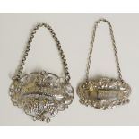 Two silver decanter labels, the first an early Victorian example, pierced,