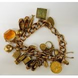 A 9ct gold Victorian textured large curb link charm bracelet hung 19 charms including Edward VII