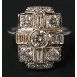 An 18ct gold diamond ring in Art Deco style centred on a collet set circular brilliant flanked by